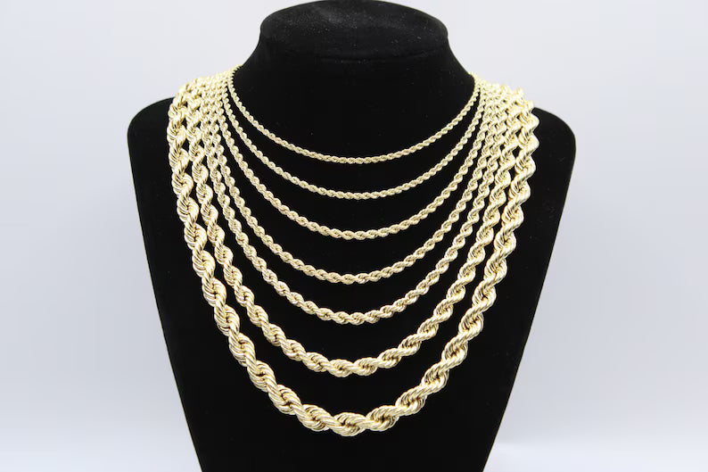 Gold chain necklaces displayed on a black mannequin bust.