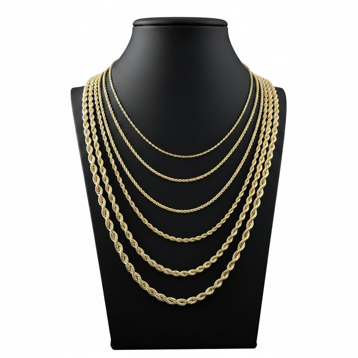 Gold chain necklaces displayed on a black mannequin bust.