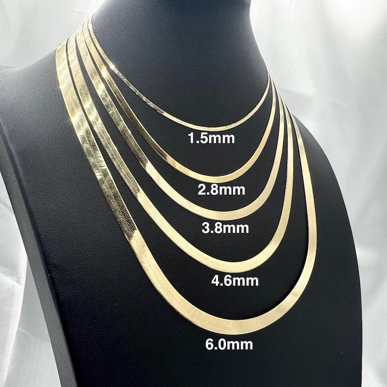 Five gold-tone snake chain necklaces displayed on a black mannequin bust, labeled with thickness measurements: 1.5mm, 2.