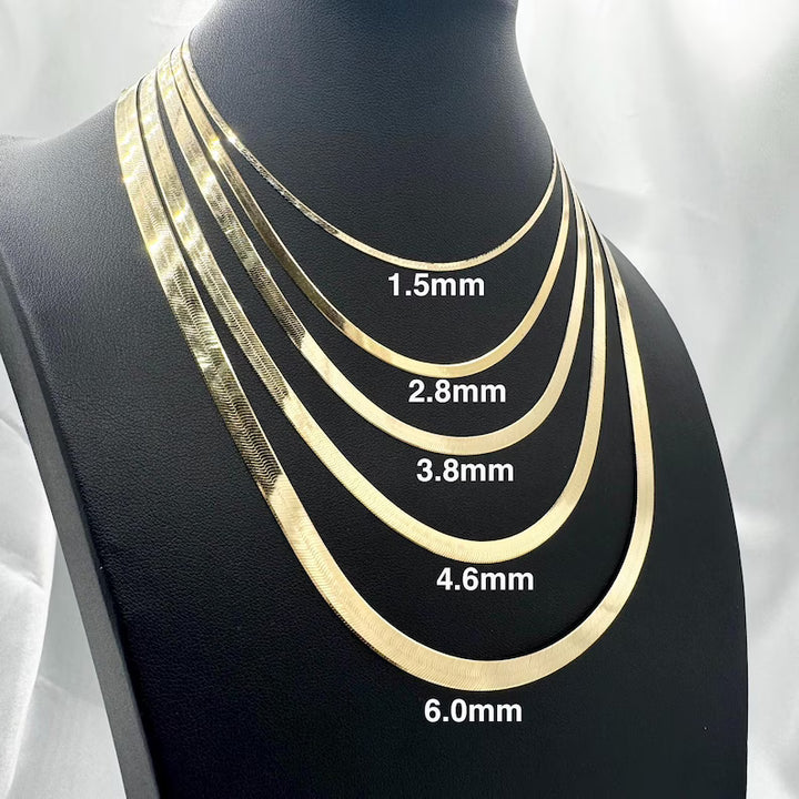 Five gold-tone snake chain necklaces displayed on a black mannequin bust, labeled with thickness measurements: 1.5mm, 2.